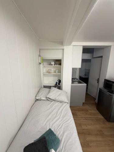 a small white room with a bed in it at Le petit Rouennais in Rouen