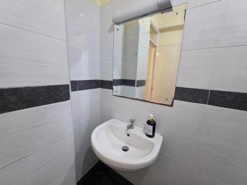 a bathroom with a sink and a mirror at Jay Homes - Modern & Cozy Apartments PGS Plaza - Nakuru CBD in Nakuru