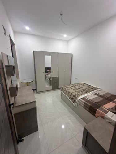 una stanza bianca con un letto, una scrivania e un letto sidx sidx sidx sidx di cartier a Baghdād