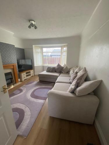 a living room with two couches and a rug at Spacious Dinnington bungalow in Dinnington