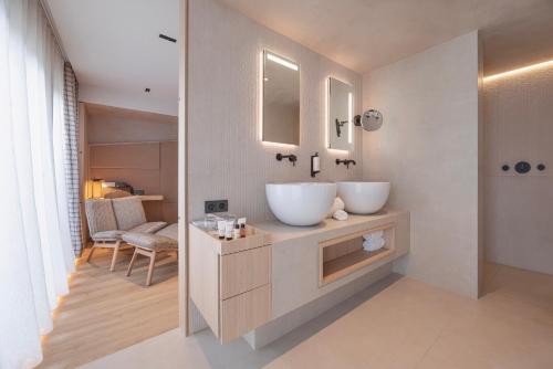 a bathroom with two white sinks on a counter at YONA ex Le Parc Hôtel in Obernai