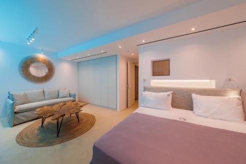 a bedroom with a large bed and a couch at Penthouse Villa with Private Pool, Sauna & Seaview in Gialova
