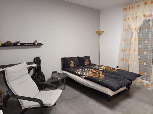 a bedroom with a bed and a white chair at Traumhaus in der Eifel in Hellenthal