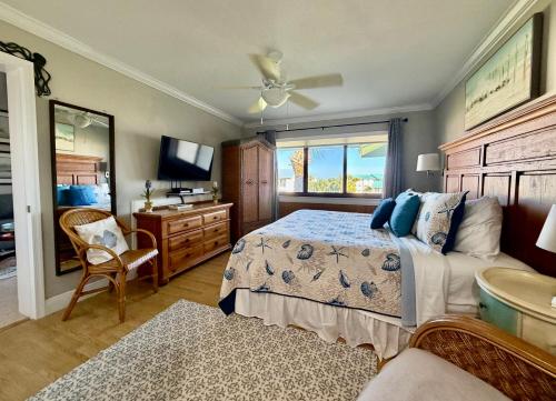 a bedroom with a bed and a dresser and a television at Beachfront paradise Ocean Village Golf Tennis Several heated pools Tiki bar Pickleball insite sports bar and restaurant and much more in Fort Pierce