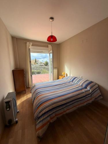 a bedroom with a bed and a window and a television at Casa con encanto en Monachil in Monachil