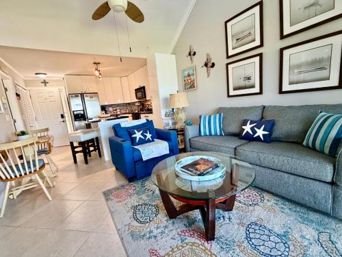 a living room with a blue couch and a table at Beachfront paradise Ocean Village Golf Tennis Several heated pools Tiki bar Pickleball insite sports bar and restaurant and much more in Fort Pierce