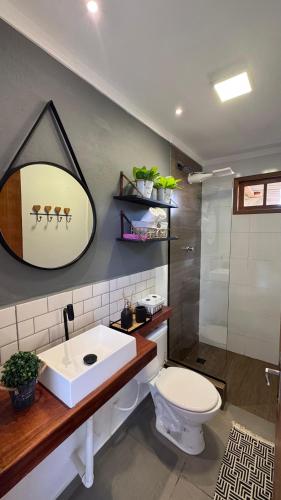 a bathroom with a sink and a toilet and a shower at Chácara Pôr do sol in Alfenas