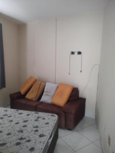 a living room with a brown couch in a room at Apto mongagua in Mongaguá