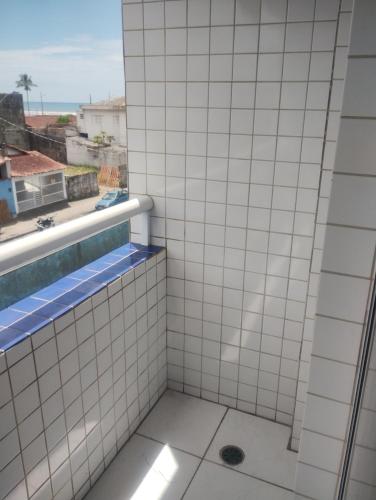 a tiled shower with a view of the ocean at Apto mongagua in Mongaguá