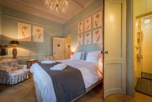 a bedroom with a large bed and a chandelier at Logement aan de Vecht in Breukelen