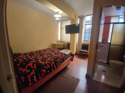 a bedroom with a bed and a sliding glass door at Hotel Savoy in La Paz