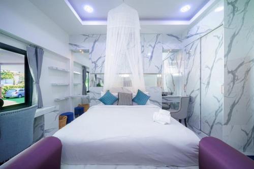 a bedroom with a large white bed and a tv at Kate Pool Villa Jomtien Pattaya in Pattaya