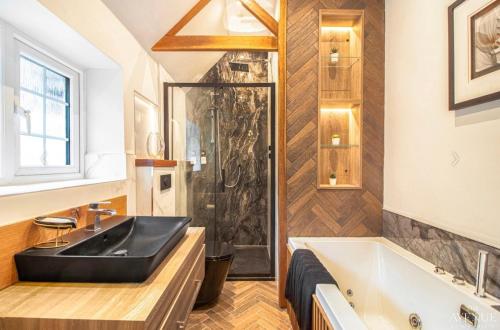 a bathroom with a black sink and a tub at Ideal Stay for Business Travellers, Contractors, and Families near NEC, Belfry, Birmingham Resorts World, and Drayton Manor in Birmingham