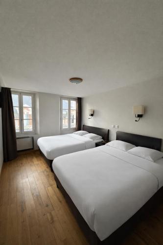 three beds in a room with white sheets and windows at Hôtel Belle Fontainebleau in Fontainebleau