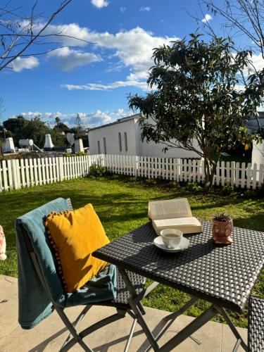 a table and chair with a book on it at Villa Valentina-Sunny 2 Bedroom House with Pool in Carvoeiro