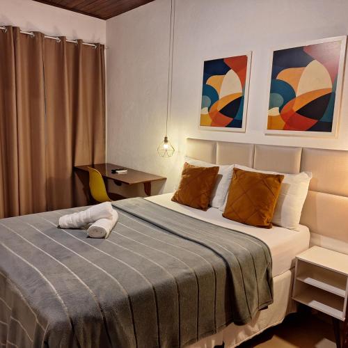 a bedroom with a large bed with orange pillows at Pousada Schueng in Trindade