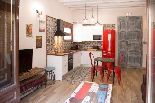 eine Küche mit einem roten Kühlschrank und einem Tisch in der Unterkunft Minicasa el Mesoncico in Cehegín