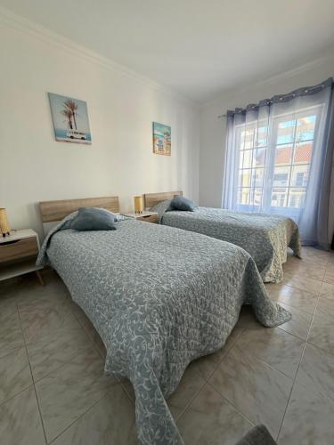 a bedroom with two beds and a window at Casa Sardine in Santo Isidoro