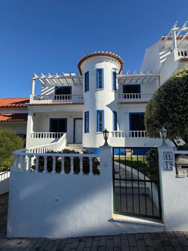 a white house with a gate in front of it at Casa Sardine in Santo Isidoro