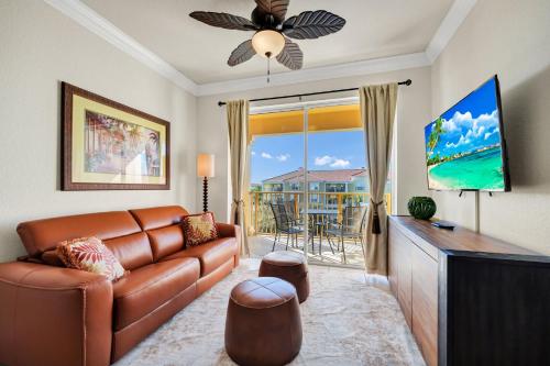 a living room with a leather couch and a television at Top Floor*Balcony*VistaCay Convention Ctr & Idrive in Orlando