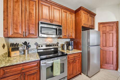 a kitchen with wooden cabinets and stainless steel appliances at Top Floor*Balcony*VistaCay Convention Ctr & Idrive in Orlando