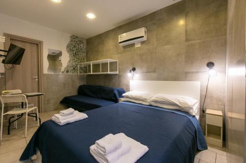 a bedroom with a blue bed with towels on it at Terrazza Miracoli & Spa Napoli in Naples
