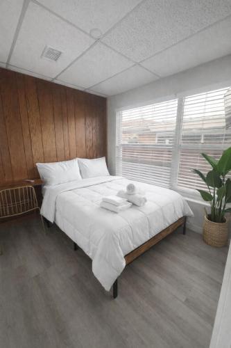 a large white bed in a room with a window at Santorini Hollywood in Hollywood