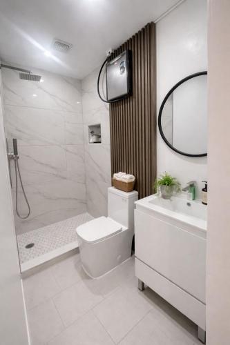 a bathroom with a toilet and a sink and a shower at Santorini Hollywood in Hollywood