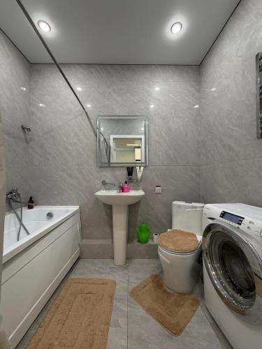 a bathroom with a sink and a washing machine in it at Walk Everywhere & Tourist Pick & Центр Города Алматы in Almaty
