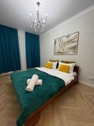 a bedroom with a large bed with two towels on it at Walk Everywhere & Tourist Pick & Центр Города Алматы in Almaty