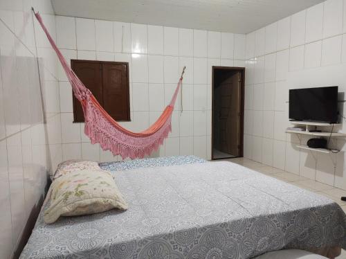 a bedroom with a bed with a hammock in it at Rosa cheirosa in Barreirinhas