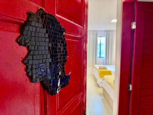 a red door with a black brick wall at Pousada Leão in Maceió