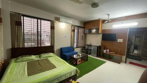 sypialnia z zielonym łóżkiem i niebieskim krzesłem w obiekcie Mirpur Dohs - Opal Peaks Suites w mieście Dhaka