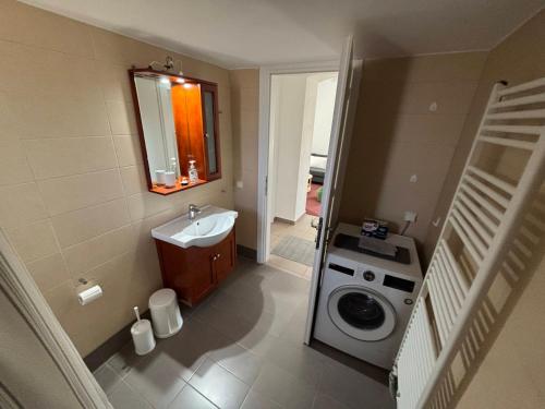 a bathroom with a sink and a washing machine at Horizon in Kythira