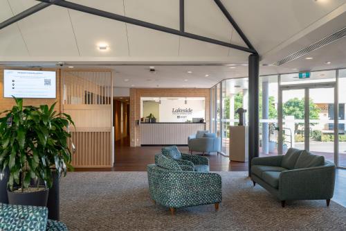 a lobby with couches and chairs in a building at Lakeside Hotel and Conference Centre in Sydney