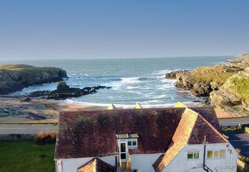 a house with a view of the ocean at GWYNFA-3 BED- GROUND FLOOR APT - SEA VIEWS - TREARDDUR BAY in Trearddur