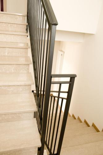 a staircase with black railings and white walls at B&B Daniel in Silea