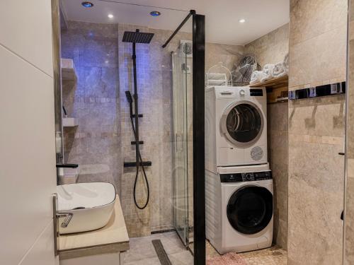 a washer and dryer in a bathroom with a shower at Appartement convivial pour séjourner in Le Kremlin-Bicêtre
