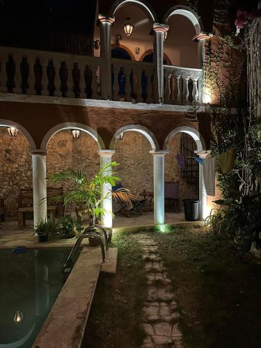 a building with a swimming pool in a yard at night at Casa Bahareque Merida in Mérida