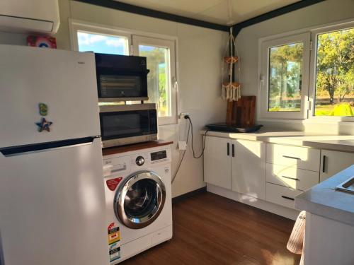 a kitchen with a washing machine and a refrigerator at Cabin on the Creek in Boyne Island
