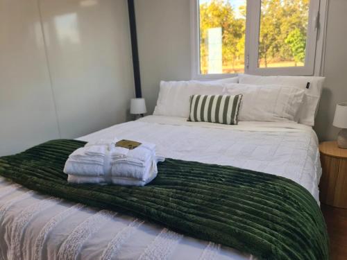 a bed with two towels sitting on top of it at Cabin on the Creek in Boyne Island