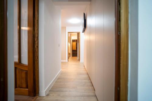 a hallway with white walls and a wooden floor at FF Residence in Deva