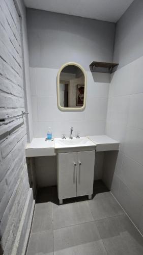 a white bathroom with a sink and a mirror at Departamento b privado cerca arena Maipú p4 personas cochera in Maipú