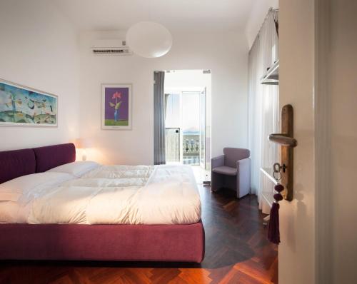 una camera con un letto e una sedia e una finestra di B&B Dumbolo a Pozzuoli