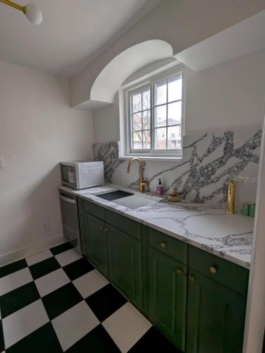 a kitchen with green cabinets and a window at Pittsburgh Getaway - Private Home- 2 Beds in Pittsburgh