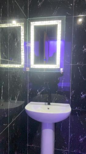 ein Badezimmer mit Waschbecken und Spiegel in der Unterkunft Relaxe casa in Thiès