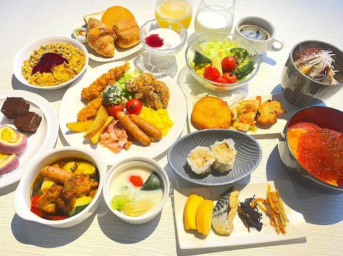 a table with many different dishes of food on it at HOTEL AMANEK Asahikawa in Asahikawa