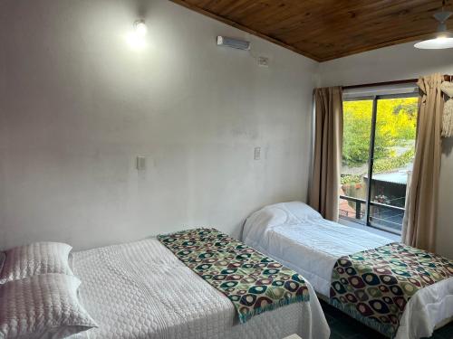 a bedroom with two beds and a window at Monoambiente Noah in Ezeiza