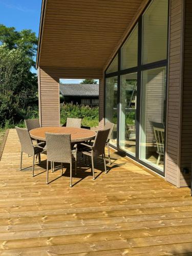 a wooden deck with a table and chairs on it at Modern House In Second Row At Rude Strand in Odder