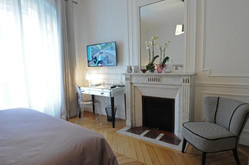 a bedroom with a fireplace and a desk with a mirror at Relais12bis Bed & Breakfast By Eiffel Tower in Paris